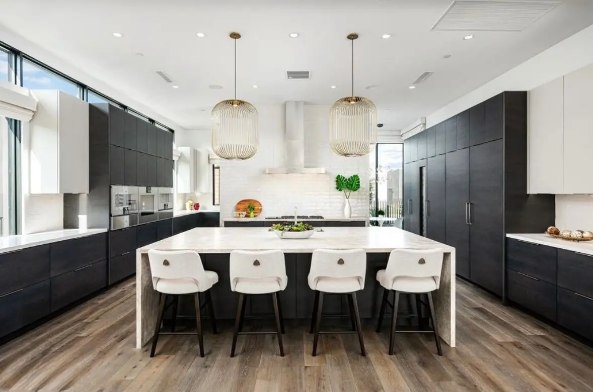 Modern kitchen: waterfall island and brass pendants